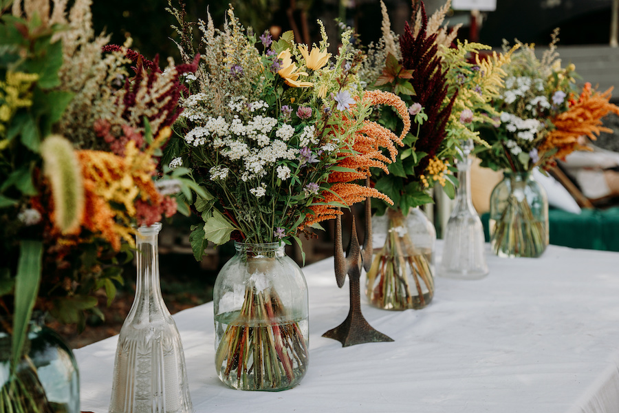 A variety of bouquets displayed in mix and match vases.