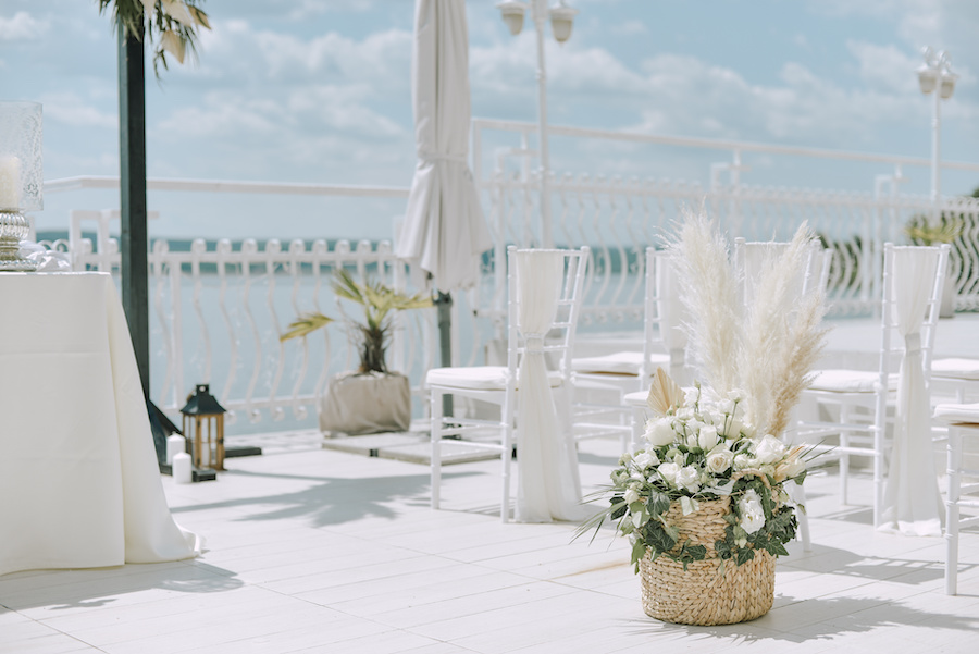 Photo of an outdoor summer wedding with a flower arrangement in a woven basket