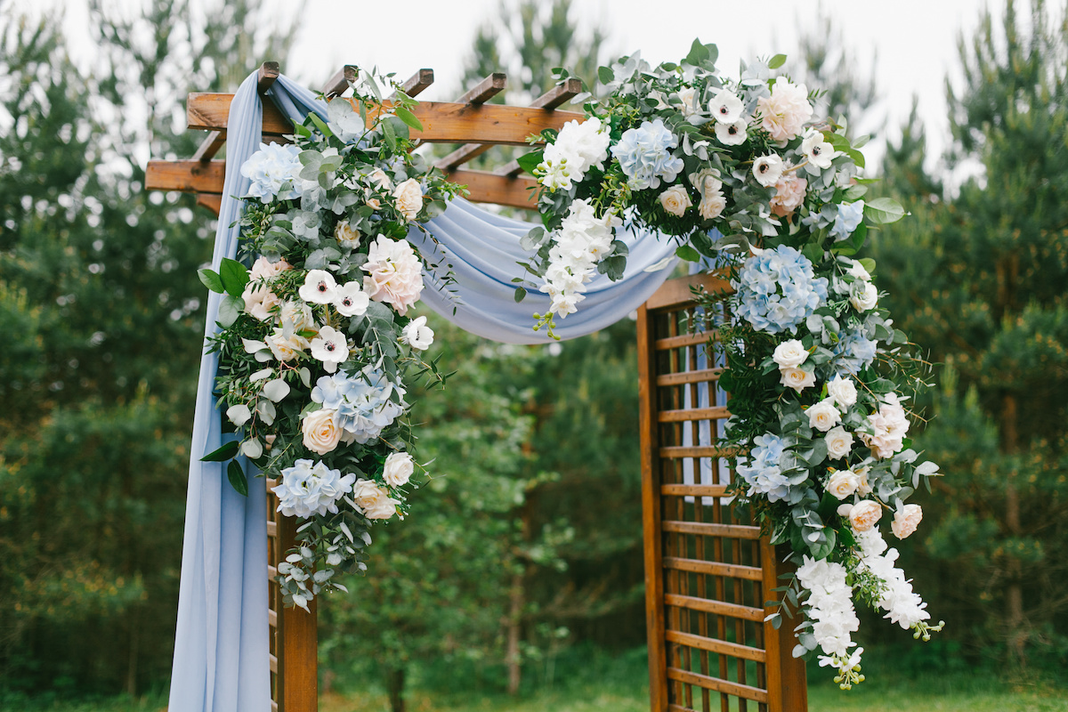 A floral archway design that features stunning flowers and foliage.