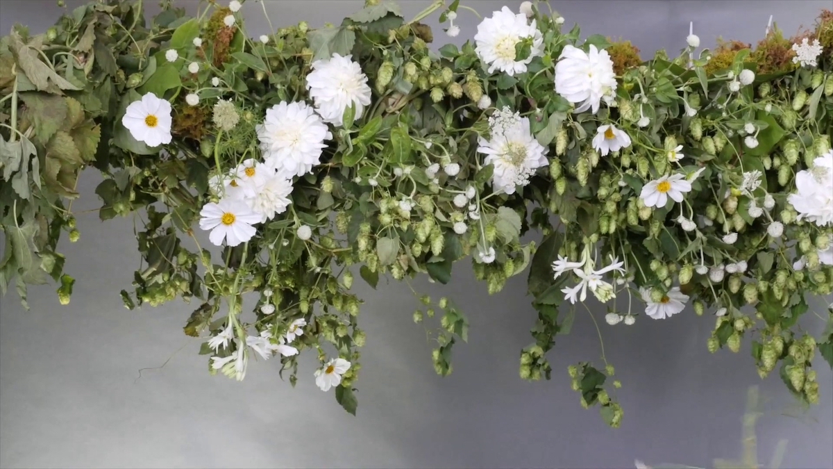 A suspended foliage centerpiece with white flowers.