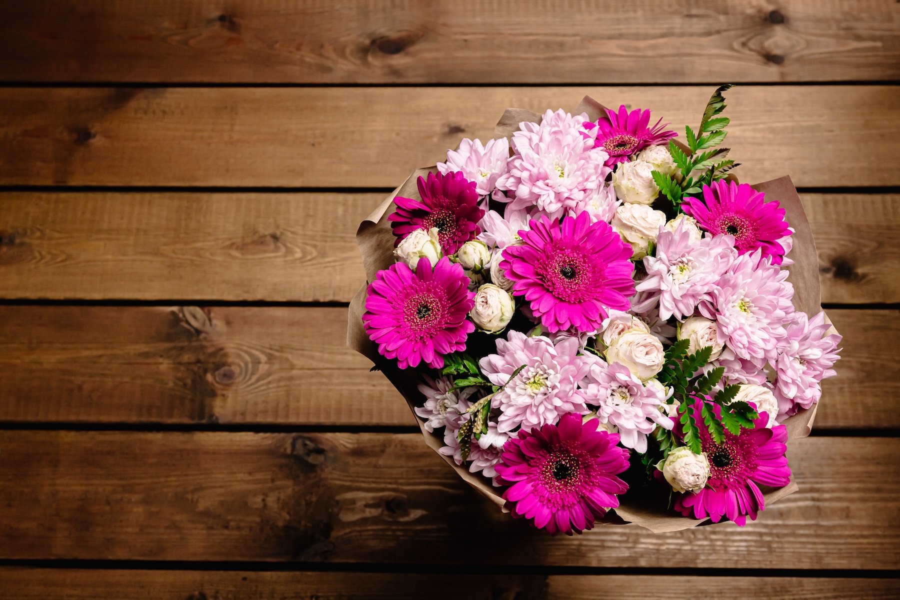 A vibrant Mother's Day bouquet of magenta and pink flowers, interspersed with greenery.